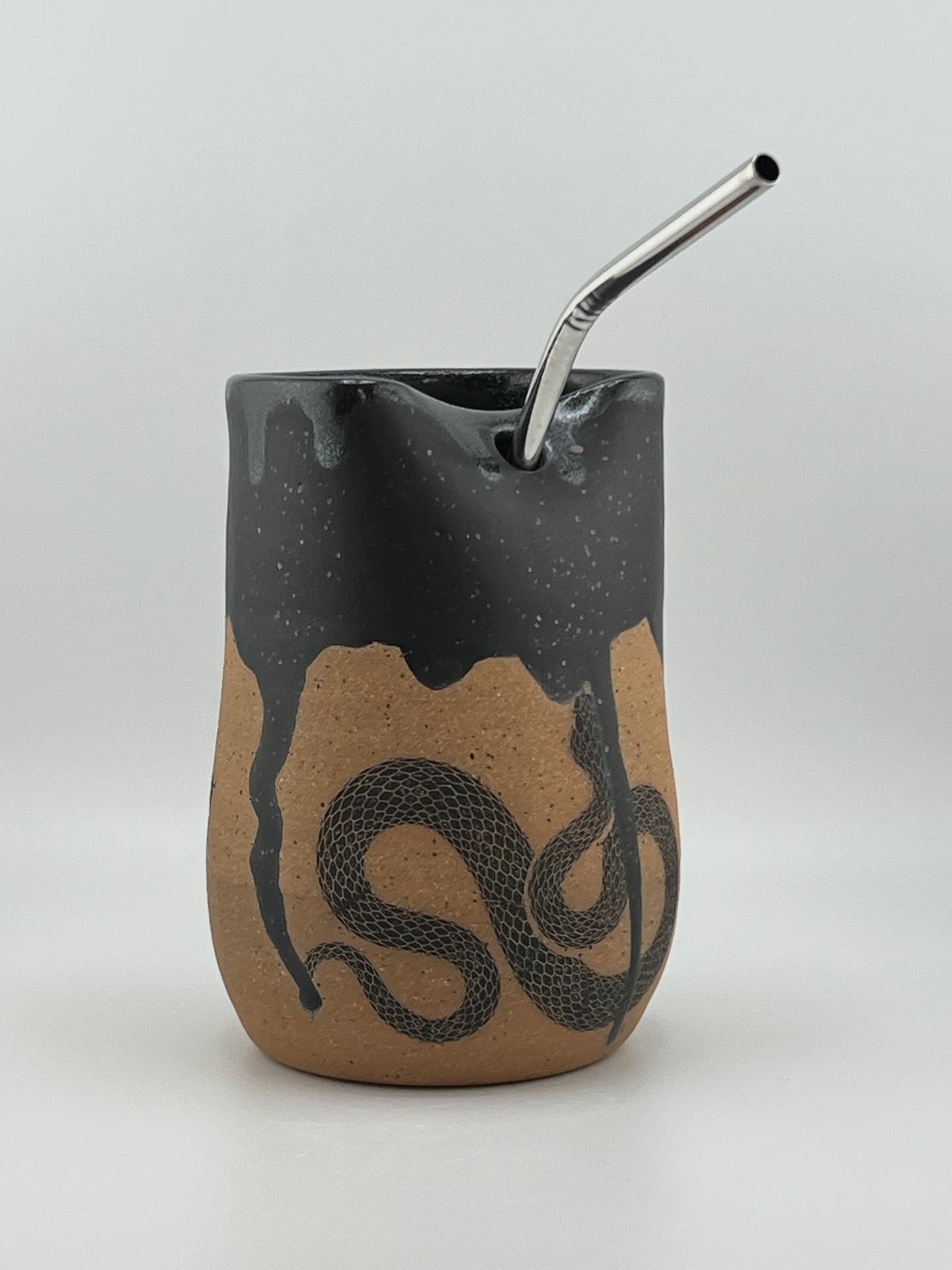 This Cold Cup is made with Speckled Turtle clay. The glaze is Satin Black with an underglaze snake transfers by @elantransfers Available at the New Albany Farmer’s Market tomorrow, 09/20/25. If it doesn’t sell then I’ll bring it to my booth at the Portland Art & Heritage Fair at the Portland Museum 09/27/25.